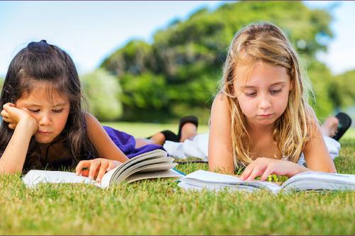 Two girls reading outside